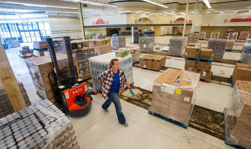 Warehouse manager Autumn Majack moves pallets of food on Wednesday, April 29, 2020 in the Puyallup Food Bank’s new temporary location in the old Safeway at Valley Plaza.