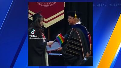 SPU grads protest anti-LGBTQ+ policy by handing Pride flags to university president at graduation