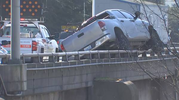 Crash leaves truck resting atop rail on elevated section of I-5 in Seattle