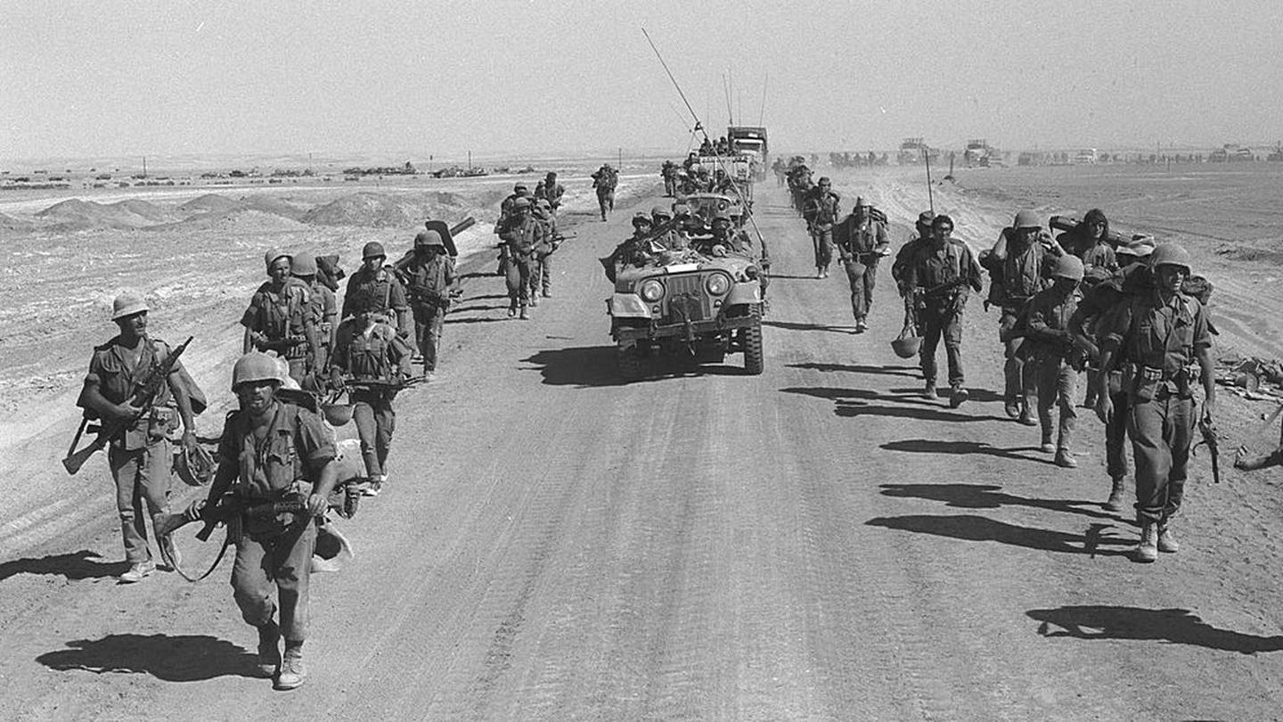SUEZ-CAIRO ROAD, EGYPT -OCTOBER 25: (FILE PHOTO) Israeli  paratroopers march October 25, 1973 along the Suez-Cairo road on the western bank of the Suez Canal during the Yom Kippur War. Current Israeli Prime Minister Ariel Sharon, then a general in the Israeli army, refused to rule out another surprise attack similar to the one launched by the Arab armies when they struck against Israeli troops in the Sinai Desert and Golan Heights on the holiest day of the Jewish calendar on October 6, 1973. (Photo by Ilan Ron/GPO/Getty Images)