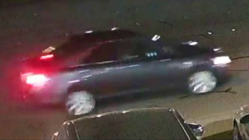 This vehicle of interest  appears to be a dark sedan, possibly a Toyota Corolla.