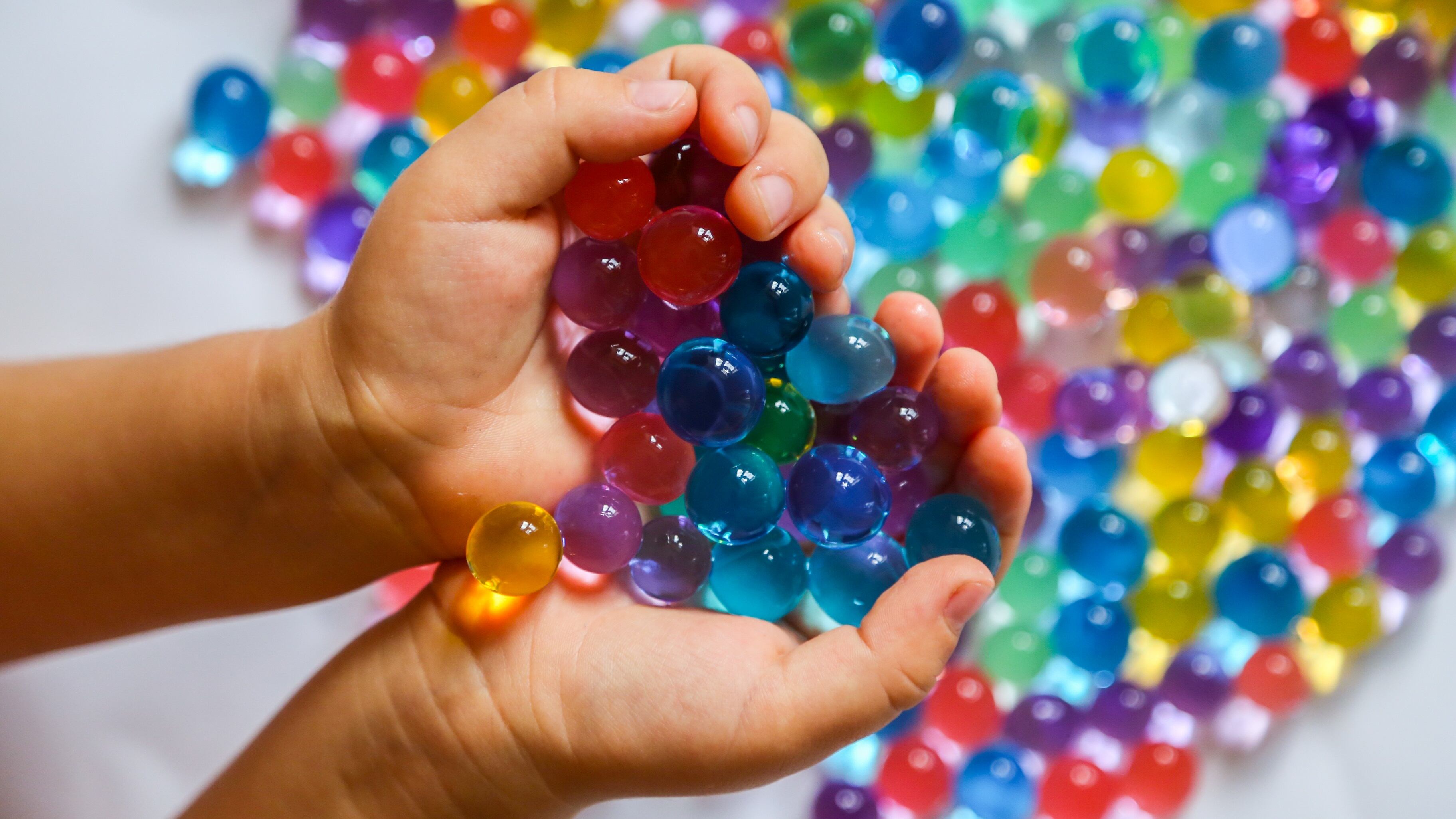 A child's hands full of water beads.