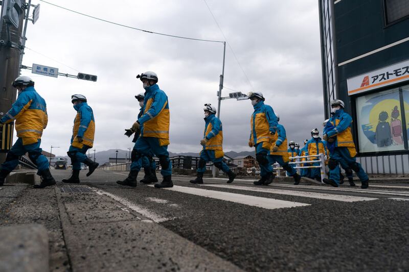 WAJIMA, JAPAN - JANUARY 05: Police officers cross a road as they search for survivors in the aftermath of an earthquake on New Year's Day on January 05, 2024 in Wajima, Japan. A series of major earthquakes have reportedly killed at least 92 people, injured dozens more and destroyed a large amount of homes. The earthquakes, the biggest measuring 7.1 magnitude, hit the areas around Ishikawa, Toyama and Niigata in central Japan on Monday. (Photo by Tomohiro Ohsumi/Getty Images)