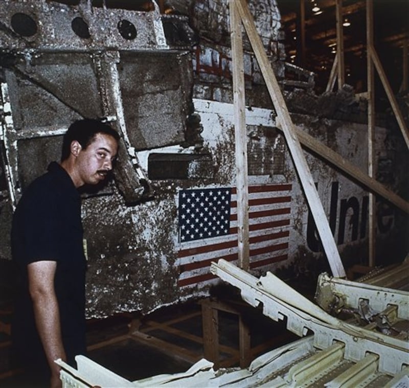 John White, National Transportation Safety Board inspector, stands near the left side of the wreckage of the Space Shuttle Challenger, Wednesday, April 10, 1986, Kennedy Space Center, Fla. The press was allowed to view the Challenger wreckage for the first time. (AP Photo)