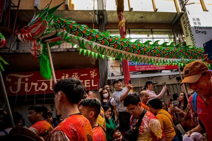 MANILA, PHILIPPINES - FEBRUARY 10: Filipinos watch dragon dancers perform during Lunar New Year celebrations at Binondo district, considered the world's oldest Chinatown, on February 10, 2024 in Manila, Philippines. Lunar New Year, also known as Chinese New Year, is celebrated around the world, and the year of the Wood Dragon in 2024 is associated with growth, progress, and abundance, as wood represents vitality and creativity, while the dragon symbolizes success, intelligence, and honor. (Photo by Ezra Acayan/Getty Images)