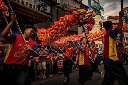 MANILA, PHILIPPINES - FEBRUARY 10: Filipinos watch dragon dancers perform during Lunar New Year celebrations at Binondo district, considered the world's oldest Chinatown, on February 10, 2024 in Manila, Philippines. Lunar New Year, also known as Chinese New Year, is celebrated around the world, and the year of the Wood Dragon in 2024 is associated with growth, progress, and abundance, as wood represents vitality and creativity, while the dragon symbolizes success, intelligence, and honor. (Photo by Ezra Acayan/Getty Images)