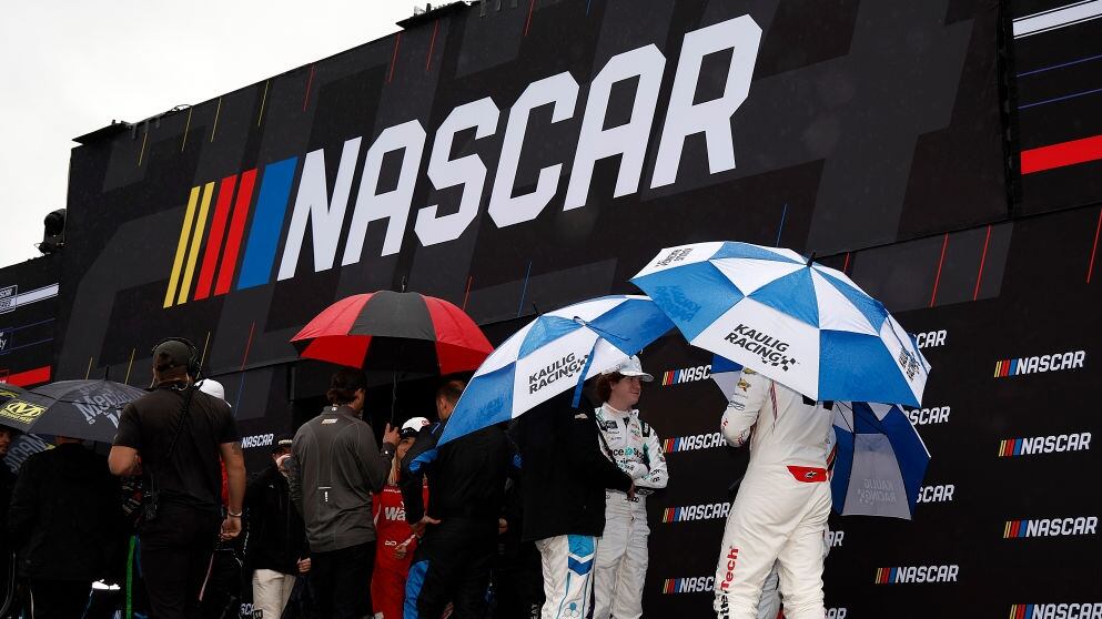 DAYTONA BEACH, FLORIDA - FEBRUARY 17: NASCAR Xfinity Series drivers under umbrellas wait backstage during pre-race ceremonies prior to the NASCAR Xfinity Series United Rentals 300 at Daytona International Speedway on February 17, 2024 in Daytona Beach, Florida. (Photo by Chris Graythen/Getty Images)
