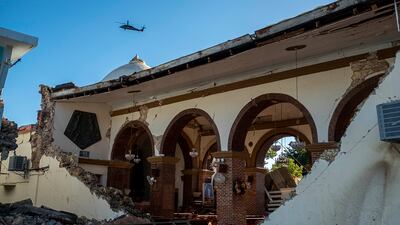 A helicopter flies over the Inmaculada Concepcion church, seen partially collapsed after an earthquake hit the island in Guayanilla, Puerto Rico, on January 7, 2020.