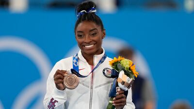 U.S. gymnast Simone Biles poses with her bronze medal for the artistic gymnastics women's balance beam apparatus at the 2020 Summer Olympics, Tuesday, Aug. 3, 2021, in Tokyo, Japan.