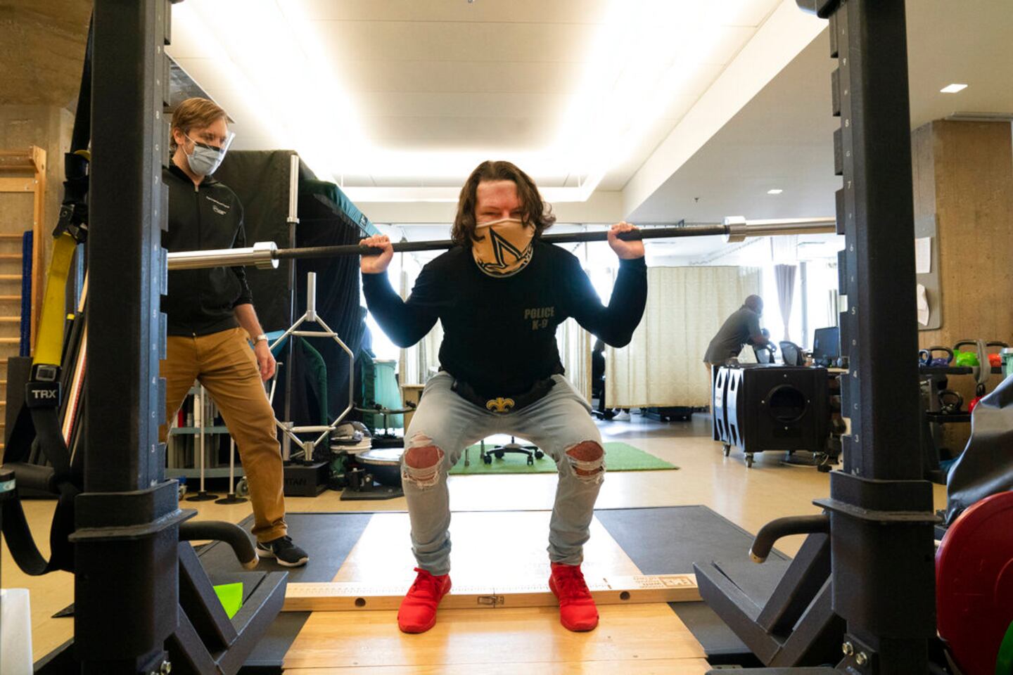 Physical therapist Eric Ross, left, watches as Joe DiMeo lifts weights, Monday, Jan. 25, 2021 at NYU Langone Health in New York. The 22-year-old New Jersey resident had a face and double hand transplant operation last August, two years after being badly burned in a car crash. “I knew it would be baby steps all the way,” DiMeo said of his recovery. “You’ve got to have a lot of motivation, a lot of patience. And you’ve got to stay strong through everything.” (AP Photo/Mark Lennihan)