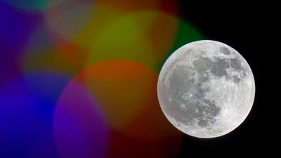 The full moon rises beyond Christmas lights, Sunday, Nov. 29, 2020, in Kansas City, Mo.