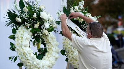 A man puts up a wreath before a candlelight vigil for the late cinematographer Halyna Hutchins, Sunday, Oct. 24, 2021, in Burbank, Calif. A prop firearm discharged last Thursday by actor Alec Baldwin, while producing and starring in a Western movie in Santa Fe, N.M., killed Hutchins and wounded director Joel Souza.