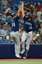 Seattle Mariners' Eugenio Suarez (28) celebrates with third base coach Manny Acta (14) after hitting a home run off Tampa Bay Rays starting pitcher Taj Bradley during the second inning of a baseball game Friday, Sept. 8, 2023, in St. Petersburg, Fla. (AP Photo/Chris O'Meara)