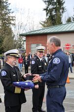 Fire Chief Ned Vander Pol presents the flag to Chief Neuhoff.